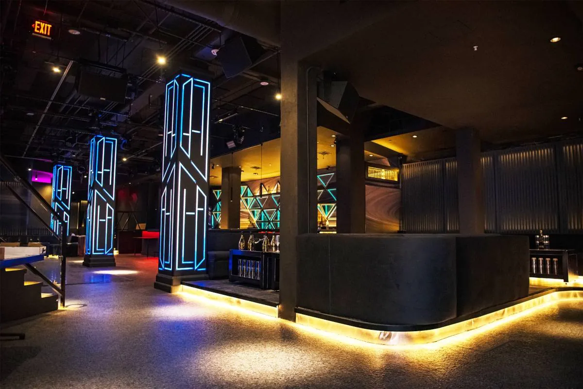 Neon line-work columns and the lit bar front at West Eight